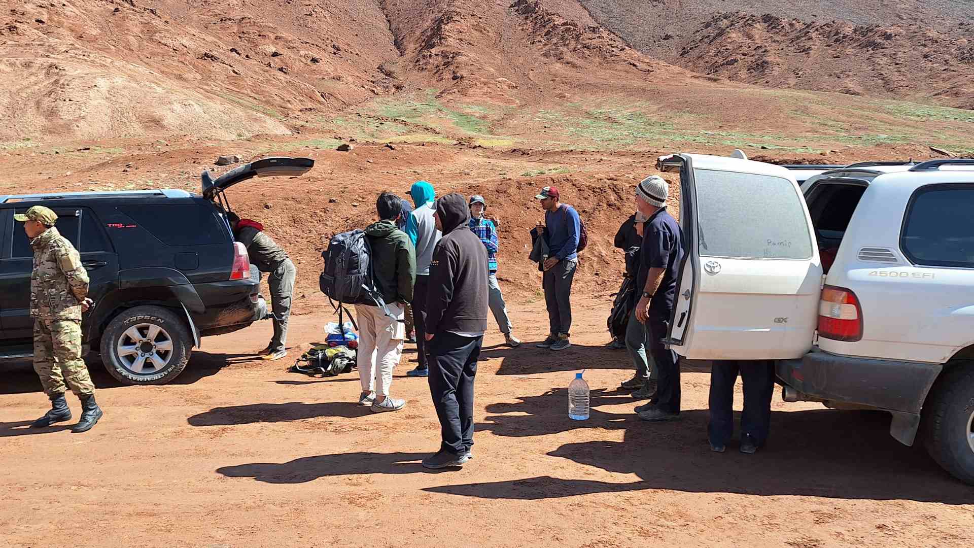 Travelers transfer from a Tajik jeep to a Kyrgyz jeep