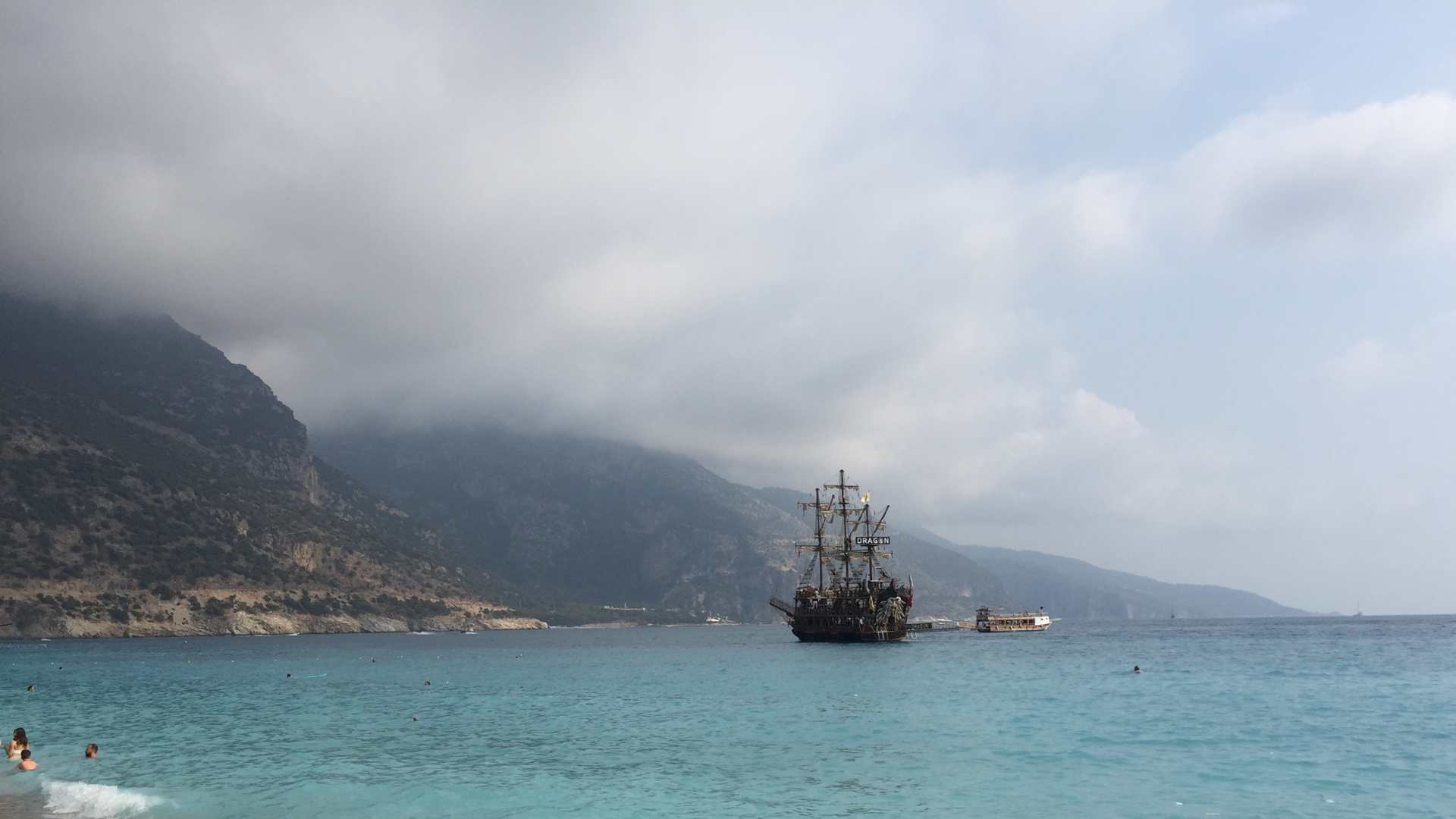 Turquoise sea, mountains and a pirate ship in Ölüdeniz